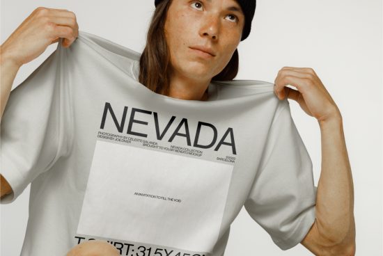 Person holding white t-shirt mockup with NEVADA print design, clear detail ideal for showcasing graphic apparel designs.