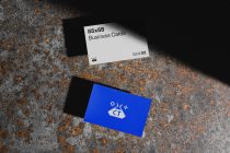 White business card with black text, blue card with beige pixelated logo below