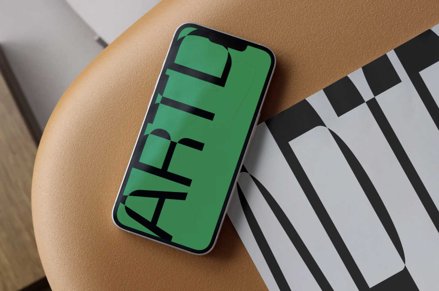 Smartphone on leather chair displaying green screen with text, ideal mockup for app design or branding presentation.