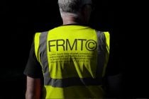 Neon yellow safety vest with reflective patterns worn from rear view angle