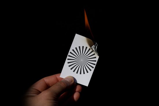 Burning paper with radial pattern in hand, dramatic effect for graphic design or Photoshop template, isolated on black background.