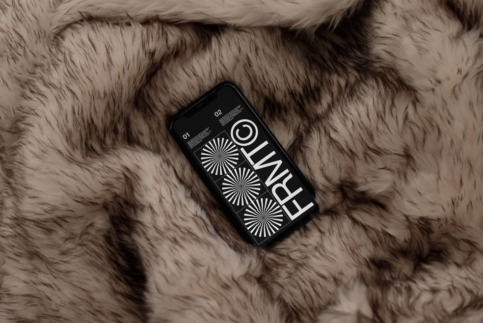 Black phone mockup with geometric sunburst design on tan fur background