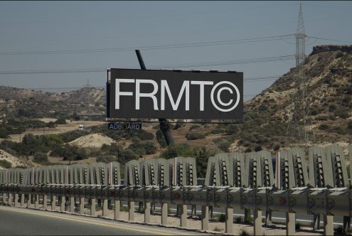 Billboard mockup on a sunny hillside beside a highway, showcasing bold text design, ideal for graphic presentations and advertising designs.