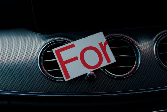 Close-up of a car grill with a red and white 'For' sign, ideal for vehicle sale graphics, mockups, and advertising templates.