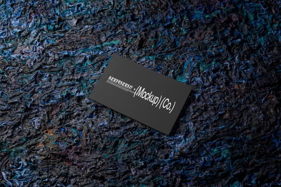 Black business card on rippled blue teal bark surface with white text design
