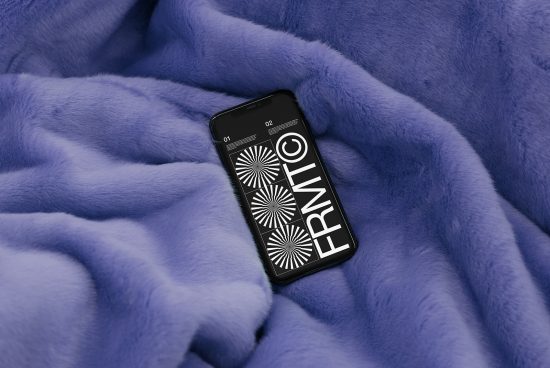 Smartphone with graphic design mockup on screen lying on a textured blue fabric surface, ideal for showcasing UI/UX design work.