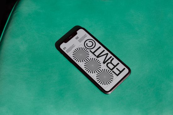 Smartphone on green surface displaying black and white graphic design, ideal for Mockup category in digital asset marketplace.