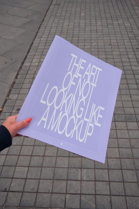 Lavender poster mockup held up outdoors on textured pavement with cream colored text
