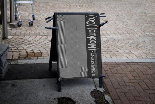 Outdoor sandwich board sign mockup on a cobblestone pavement for showcasing branding and design projects to clients and on portfolios.