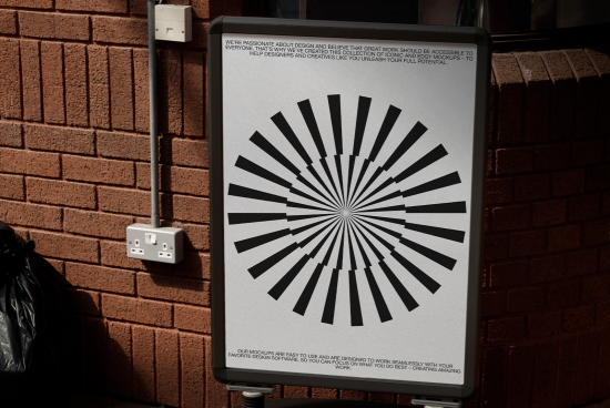 Graphic design poster mockup displayed on metal stand against brick wall, showcasing striking black and white radial lines pattern, ideal for design presentations.