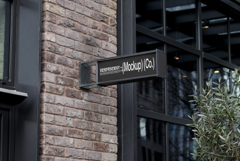 Rectangular store signboard mockup on a brick wall by a window, urban outdoor setting for graphic designers.