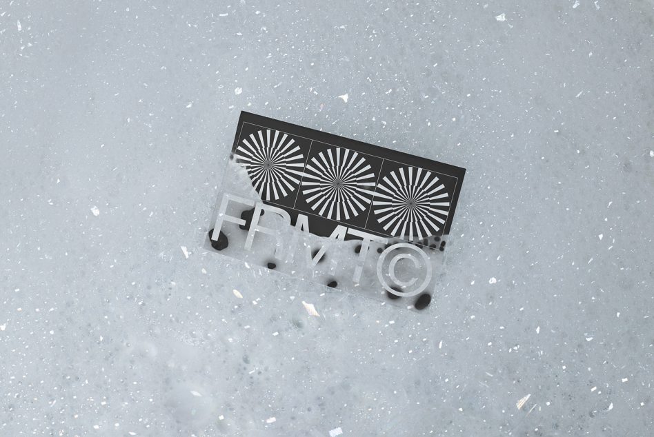 3D printed business card mockup with radial line pattern on speckled concrete