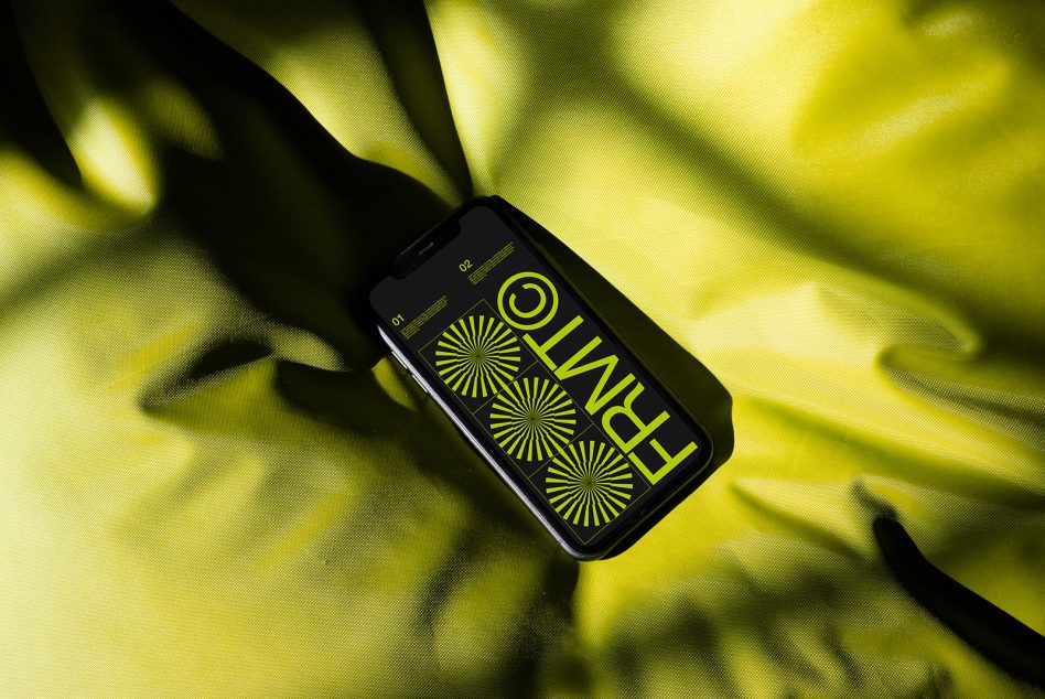 Phone with neon yellow geometric pattern on bright yellow fabric backdrop