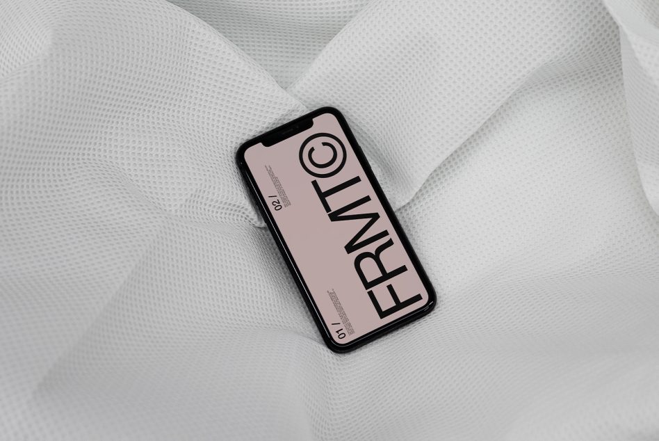 Light pink iPhone mockup on white textured fabric with bold vertical typography