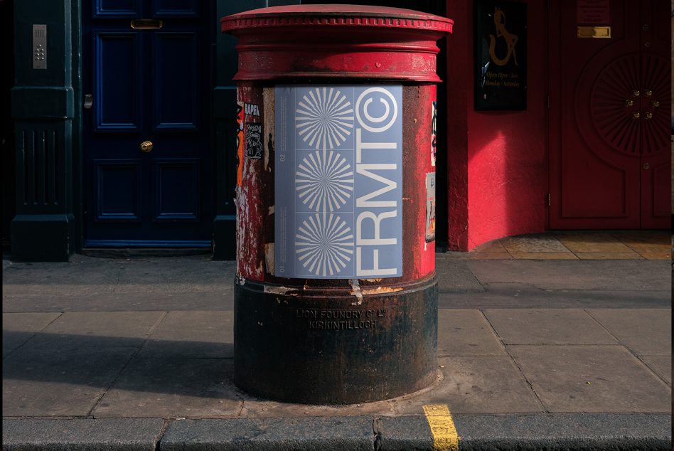 Vintage red British postbox with modern posters, ideal for mockup designs, urban textures, and street photography themes.