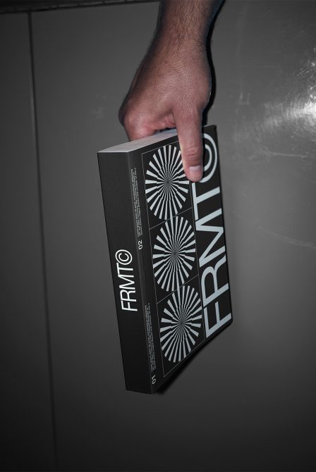 Person holding a book with a modern black cover design featuring geometric patterns, suitable for Mockups category for creative packaging presentations.