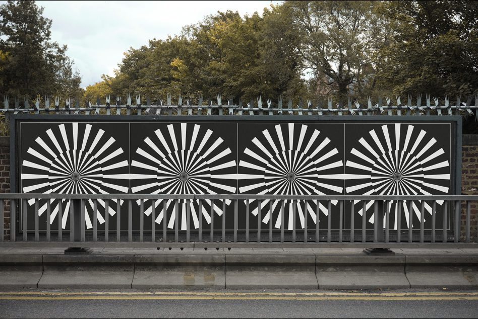 Bold geometric sunburst pattern on dark billboard with trees in background