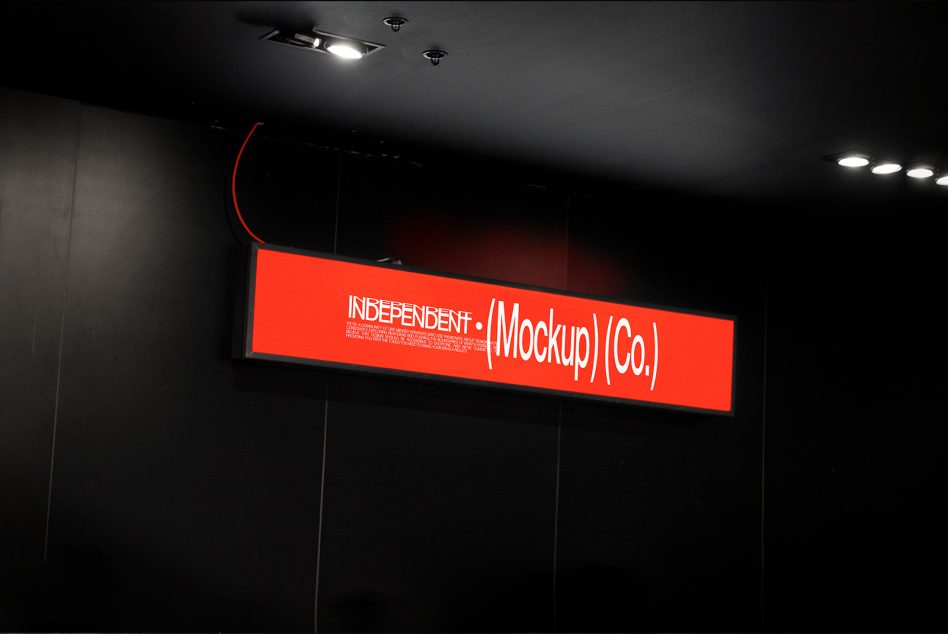 Glowing red neon storefront sign with white typography in dark interior space