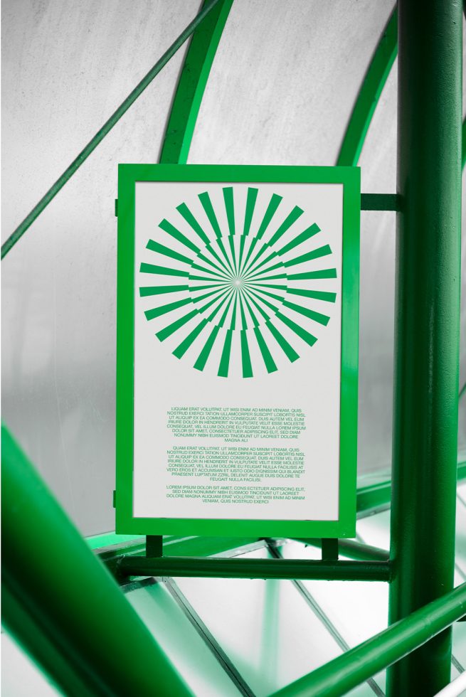 Green and white poster mockup with graphic design, positioned on metallic spiral staircase for contemporary presentation in a design studio setting.