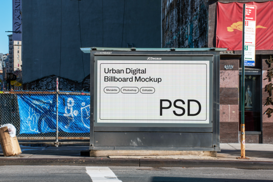 Urban digital billboard mockup on city street corner for advertising design presentation, clear sunny day, editable PSD file for designers.