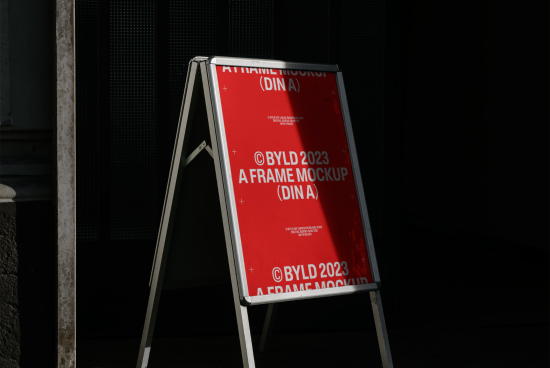 Red A-frame signboard mockup with shadow play, perfect for outdoor advertising designs and presentation. Suitable for showcasing graphics and fonts.