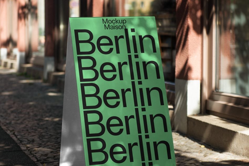 Neon green folded sign with repeated Berlin lettering casting shadow on walkway