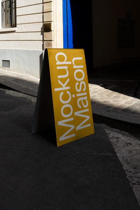 Yellow street mockup signboard with shadow in urban setting for outdoor advertising design presentation.