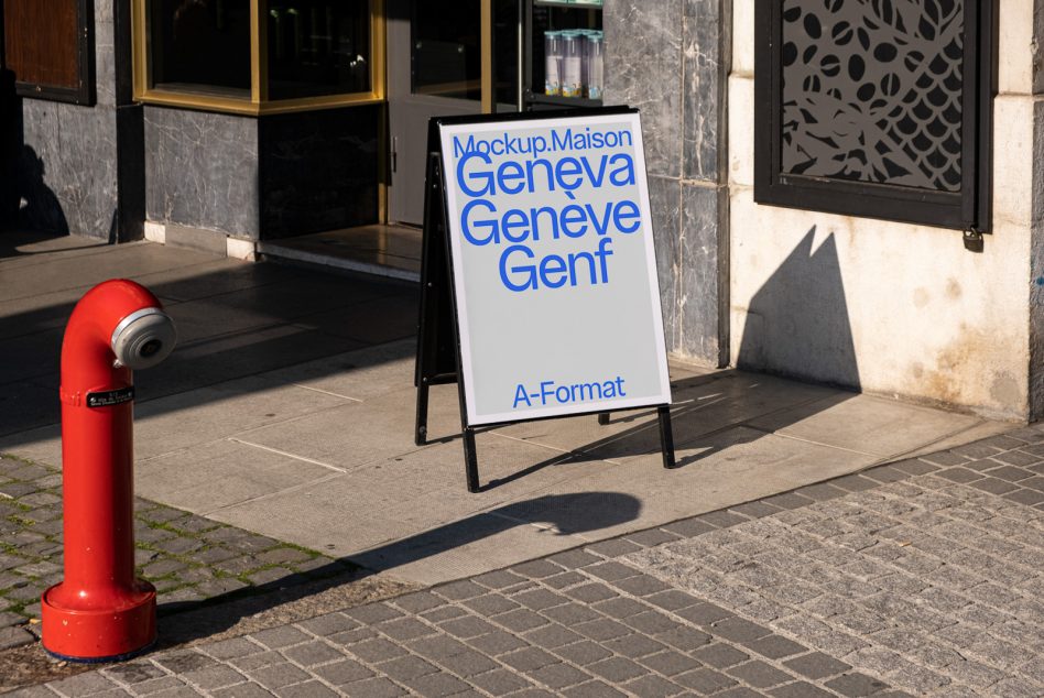 A-frame sidewalk sign with blue text positioned on street next to red fire hydrant