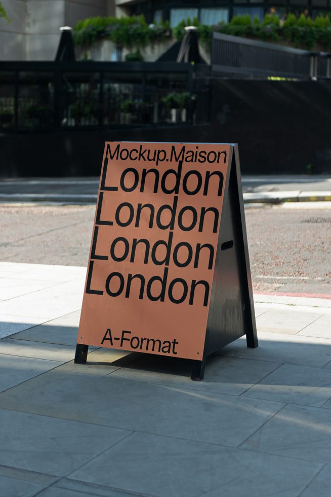 A-frame mockup display sign on a city sidewalk showcasing text design, suitable for graphic design and font styling presentations.