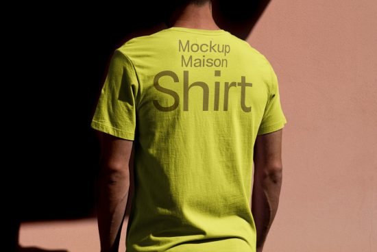 Rear view of person wearing yellow t-shirt with mockup text design, ideal for presentations in Mockups category for graphic designers.