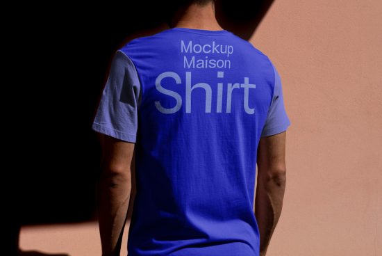 Man in blue t-shirt mockup with text design, showcasing back view, suitable for fashion designers and apparel branding.