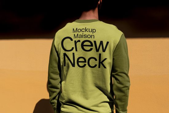 Rear view of person wearing green crew neck shirt mockup with black typography, suitable for design presentations in graphics category.