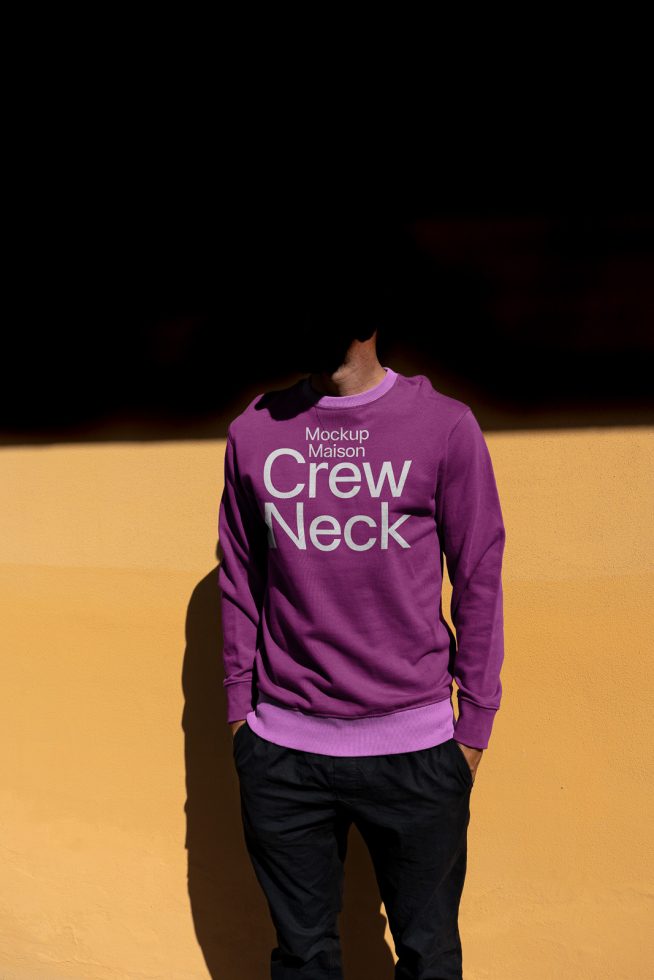 Man in purple crew neck sweater mockup, standing against yellow wall, fashion design template, apparel presentation, rear view.