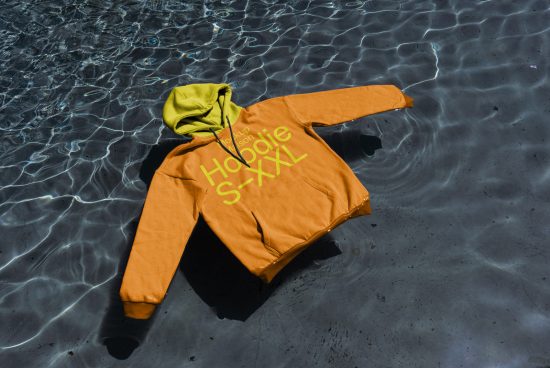 Orange and lime hoodie mockup floating on water texture, realistic apparel design presentation, fashion graphic display.