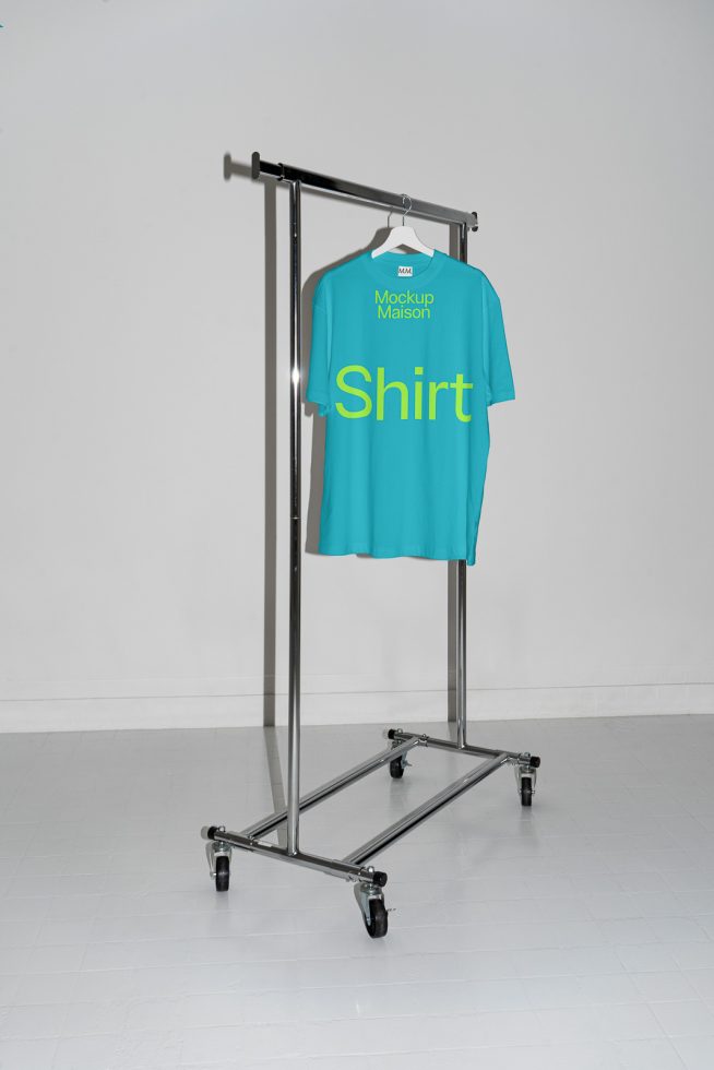 Blue t-shirt mockup on metal hanger rack in minimalist setting for apparel design presentation, clear print area.