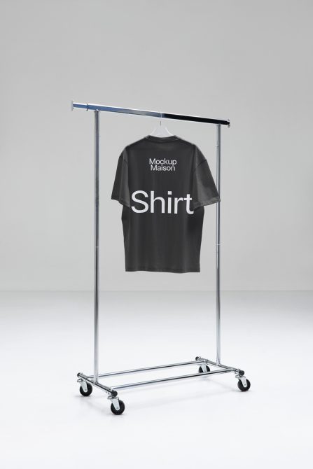 Black T-shirt on hanger rack in a minimalist setting for apparel mockup design, clean background, ideal for presentations, editable graphic.