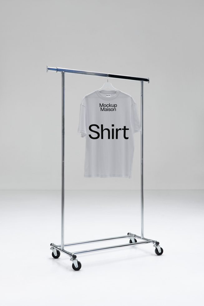 White t-shirt on metal hanger rack against a plain background for apparel mockup design presentation.