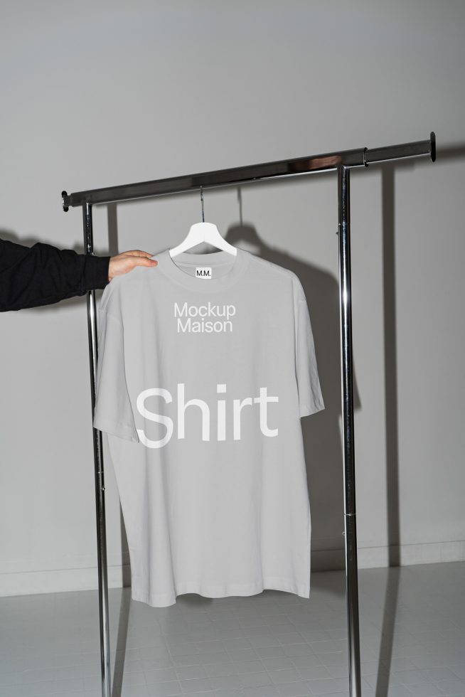 T-shirt mockup on hanger in neutral setting with editable design, ideal for presentations and apparel design by graphic designers.