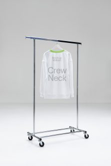 White crewneck sweatshirt on rolling rack with neon green trim