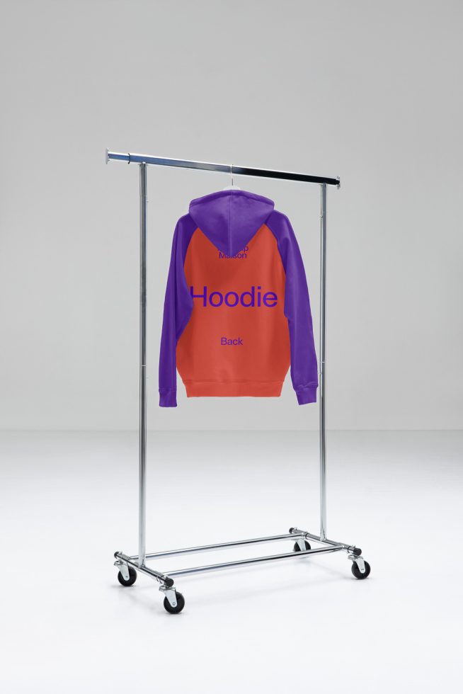 Purple and orange hoodie on clothing rack mockup in a minimalist studio setting, ideal for apparel design presentations.