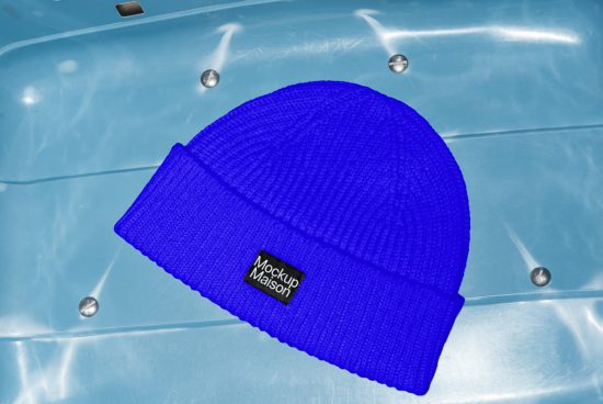 Blue knitted beanie hat mockup on a blue background, high-resolution design asset for fashion designers, ideal for showcasing logos and patterns.