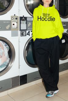 Neon yellow hoodie front view worn at laundromat with black text