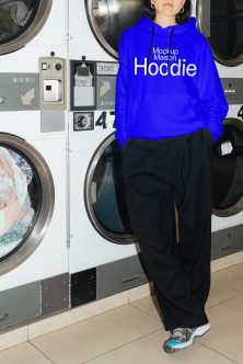Bright blue hoodie front view worn at laundromat with white text