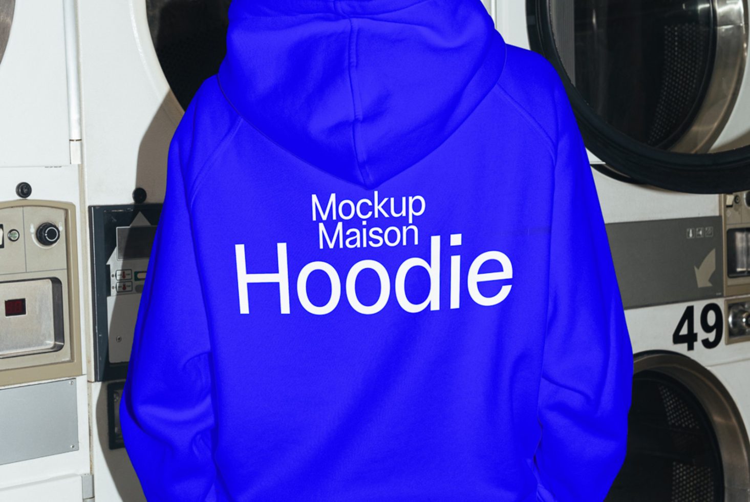 Blue hoodie apparel mockup with text design in a laundromat setting for fashion graphic presentation and template design.