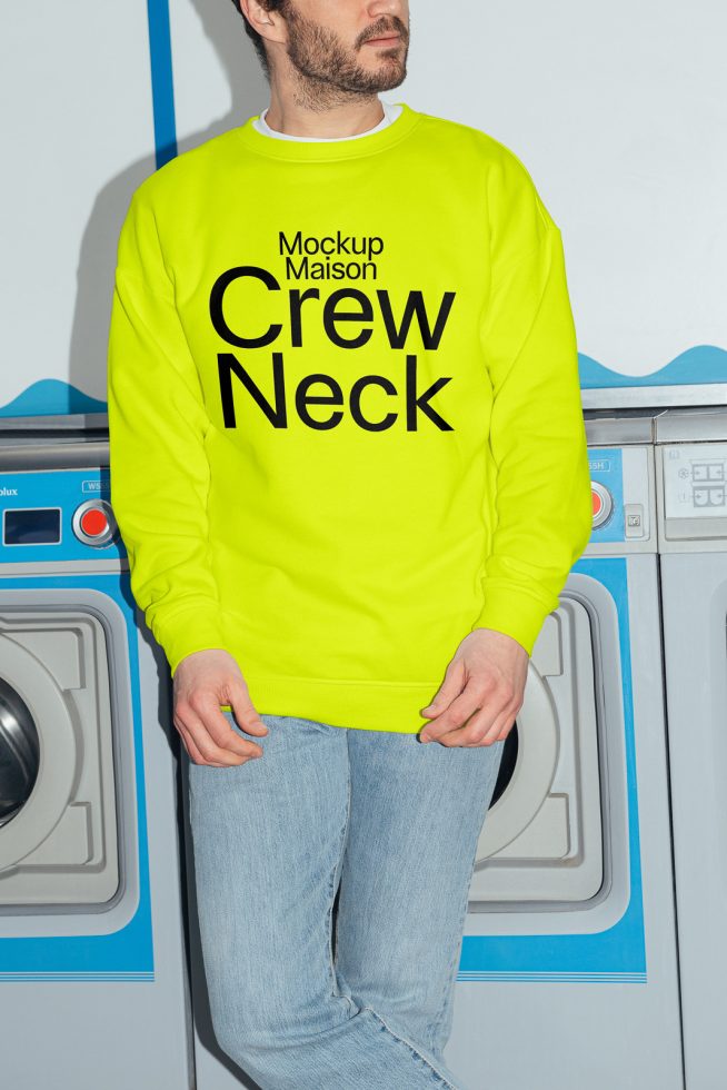 Man in neon yellow crew neck sweatshirt mockup, standing by washing machines, ideal for fashion design presentation.