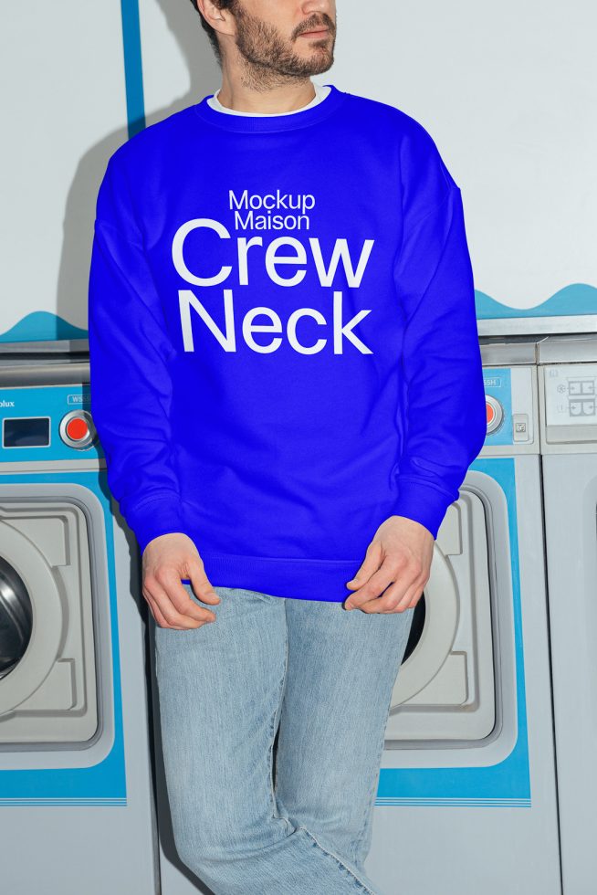 Man wearing blue crew neck sweatshirt mockup, realistic design presentation, fashion apparel, casual clothing, front view, with washing machines background.