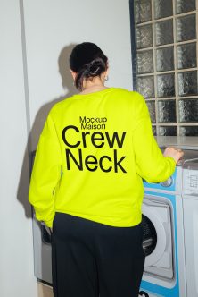 Back shot of person in neon yellow crewneck with bold black text design