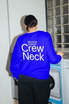 Woman wearing royal blue crewneck sweatshirt from behind in laundry room setting