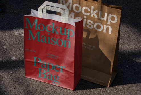 Red and brown paper bag mockups with branding for design presentation, showcasing packaging graphic design in a realistic outdoor setting.