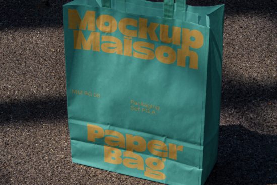 Turquoise paper bag mockup with bold golden typography on textured ground, perfect for showcasing packaging designs and branding for designers.